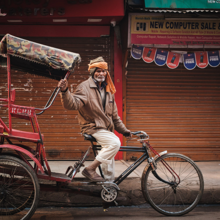 Elderly man sitting on a cycle rickshaw on the streets of Chandni Chowk in Delhi, India.