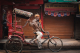 Elderly man sitting on a cycle rickshaw on the streets of Chandni Chowk in Delhi, India.